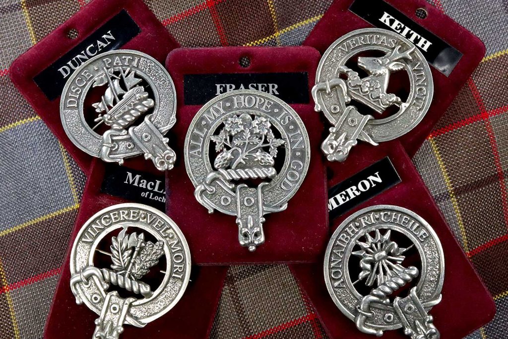 Photo of 5 metal brooches of Scottish family crests.